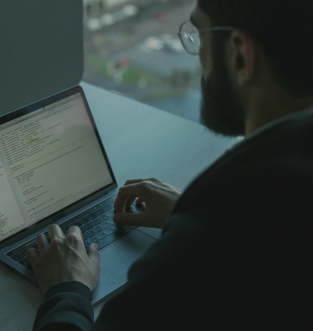 A developer writing code by a sunlit window